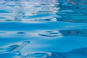 Beautiful blue ripple water surface in swimming pool with sun reflection