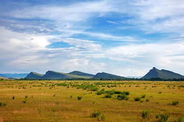 Fototapeta premium View of the mountain range Sunduki, Khakassia, Russia.Blue sky with clouds over mountains in the steppe