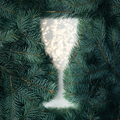 A creative concept for the new year. Silhouette of a Christmas champagne glass made of Christmas tree branches.