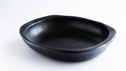 black clay plate for the dry, very traditional to serve food, used in Colombia. on white background