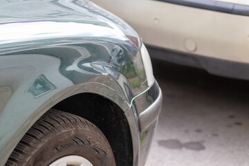 Dented car wing and fender with scratches and bumps after crash and car accident with hit-and-run driving and absconding shows need for car insurance and safety protection and mechanics garage service