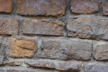 Massive stone wall with rough rocks like a castle wall with different bricks as natural background and rocky wall of ancient times shows solid bricks of stones as vintage texture for granite minerals