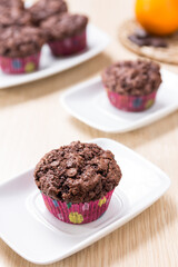 Chocolate and orange muffins on white plate