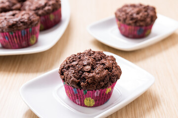 Chocolate and orange muffins on white plate