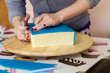 Woman hands smoothing fondant for cake decoration