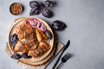 Catfish kebab. Shashlik with roasted fish on on a round plate with red onion and basil.