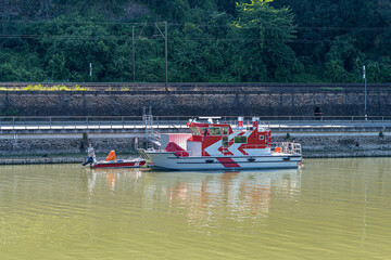 Fire boat standing on the river attached to the quay, visible road.