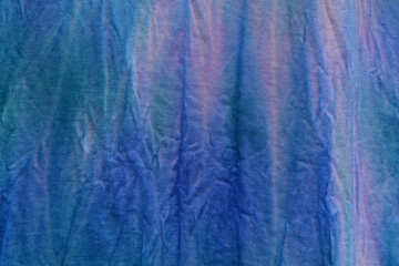 Abstract painted background. Multi-colored pattern in the shibori technique on a thin knitted fabric. Multi-color texture. Batik.Textile shibori