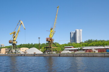 Port cranes on the embankment of the Khimki reservoir. Northern River Station in Moscow, Russia