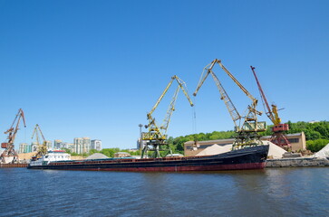 Obraz premium The Moscow Canal. Port cranes and a barge at the Northern River Station in Moscow, Russia