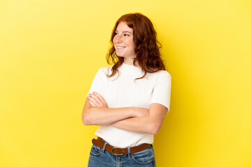 Teenager reddish woman isolated on yellow background looking to the side