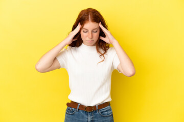 Teenager reddish woman isolated on yellow background with headache