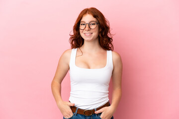 Teenager reddish woman isolated on pink background laughing