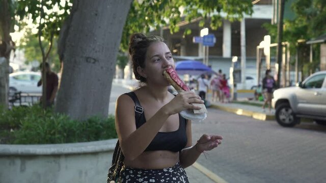 young hispanic woman eating typical mexican dessert marquesitas