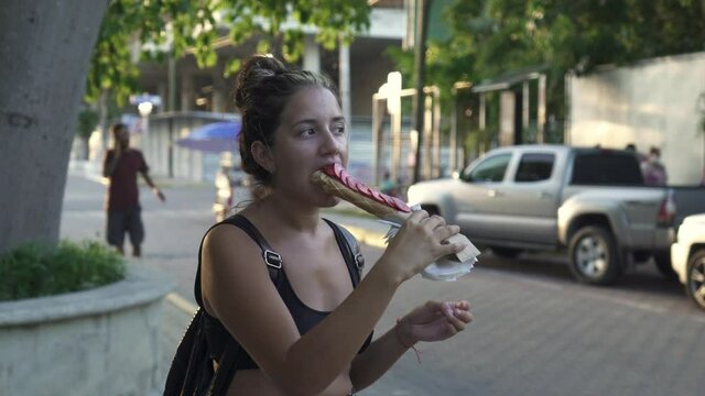 young hispanic woman eating typical mexican dessert marquesitas