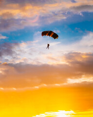 Skydiver On Colorful Parachute In Sunny Sunset Sunrise Sky