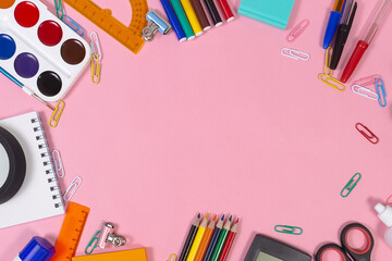 School and office supplies on a pink background