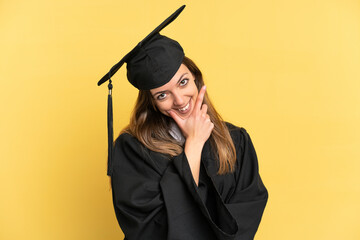 Young university graduate isolated on yellow background happy and smiling