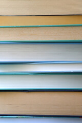 Stack of books with blue and green covers. Selective focus.