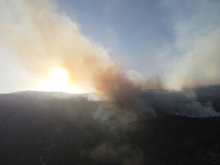 Summer forest fires. Smoke of a forest fire obscures the sun. Natural disasters. Bogsak, Mersin province, Turkey. Aerial view