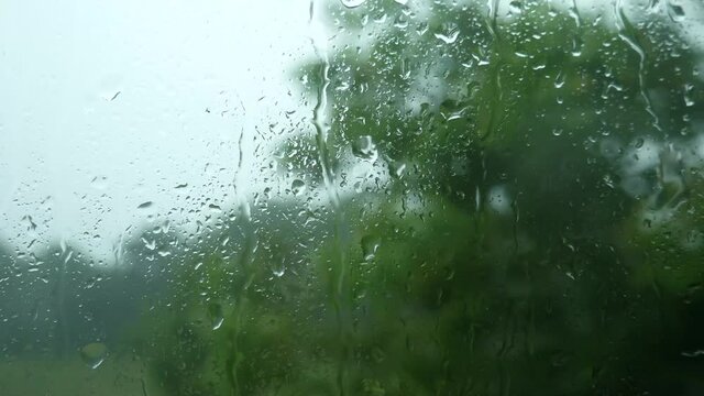 Raindrops through the glass. Storm, hurricane and strong wind through the glass