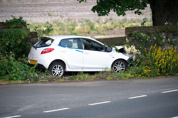 Car crash in rural countryside and damaged wall