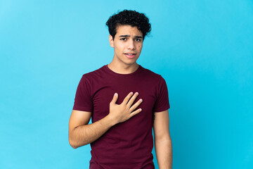 Young Venezuelan man isolated on blue background pointing to oneself