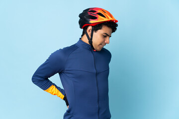 Venezuelan cyclist man isolated on blue background suffering from backache for having made an effort