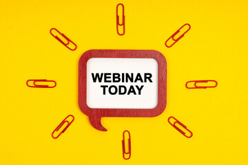 On a yellow background, paper clips and a mental plaque with the inscription - Webinar Today