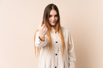 Young caucasian woman isolated on beige background doing coming gesture