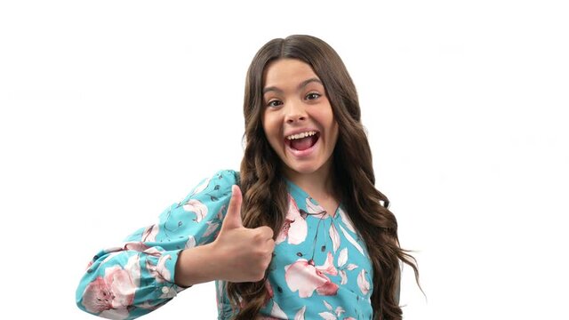 approval thumb up gesture of child with amazed happy face and curly hair isolated on white, approve