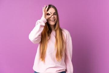 Young caucasian woman isolated on purple background showing ok sign with fingers