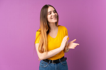 Young caucasian woman isolated on purple background applauding