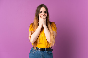 Young caucasian woman isolated on purple background happy and smiling covering mouth with hands