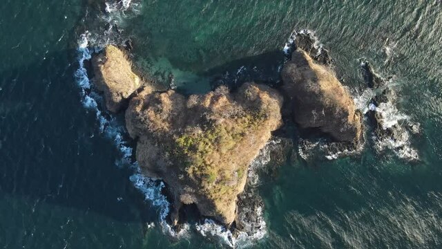 Aerial top shot over rocky islands sunset montosa Costa Rica guanacaste windy day clear water