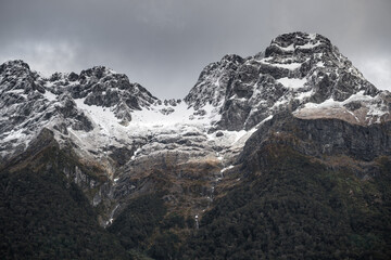 Obraz premium Mirror Lakes are a famous natural landmark omn the Milford Road in the Fiordland National Park. Snowy mountains are reflecting in a calm water. New Zealand