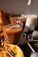 Home made iced coffee in a tall glass with a bottled of milk