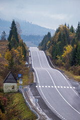 Hazy and overcast Carpathian Mountains and highway on mountain pass, Ukraine.