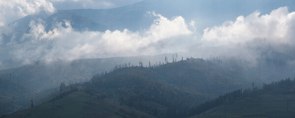 Morning foggy clouds in sunlight and autumn mountain countryside.  Ukraine, Carpathian Mountains, Borzhava Range, Transcarpathia.