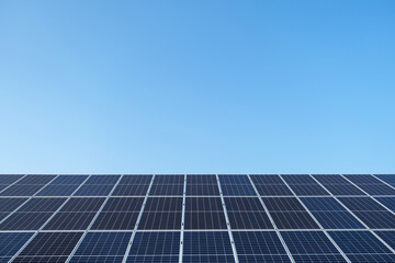 Row of solar panels on a solar farm under a blue sky. Solar power plant, an ecological alternative...