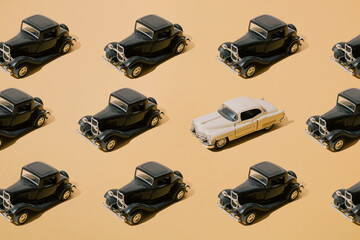 Plastic and metal old toy. Black retro car with beige limousine. Oldtimer on yellow gold luxury...