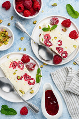 Semifreddo with raspberries and pistachios. Traditional Italian ice cream dessert.  Semifredo slices on plates. Top view