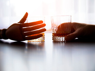 Glass of whiskey in hand. Whiskey glass. Background. Alcohol. Photo. Background. People. 