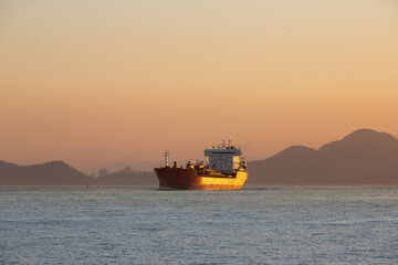 Obraz premium Freighter entering the Port of Santos, Brazil, during sunset