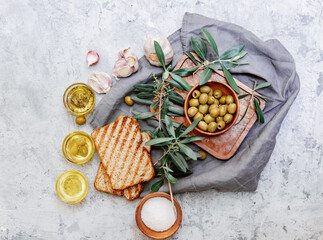 Olive oil and bread fresh branch of olives on white marble background directly above.Testing fresh...