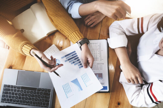 The auditor hand holding pen and budget graph document to examine the misuse of company funds.
