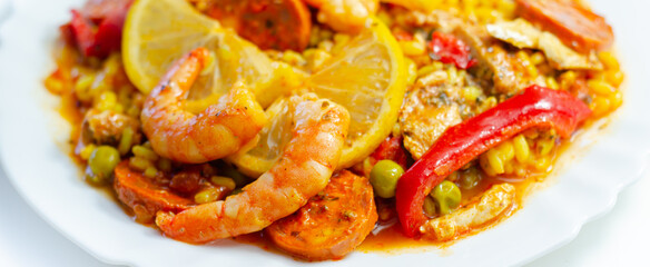 Delicious paella, cooked risotto rice with chicken thigh, king prawns, tomatoes and  chorizo