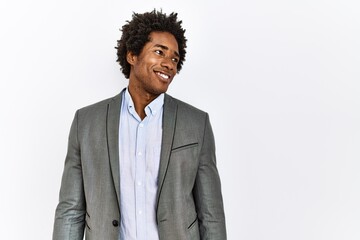 Young african american man wearing business jacket over isolated white background looking away to side with smile on face, natural expression. laughing confident.