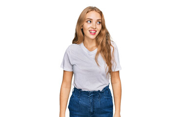 Obraz premium Young caucasian girl wearing casual white t shirt looking away to side with smile on face, natural expression. laughing confident.