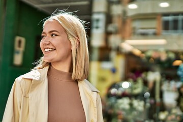 Fototapeta premium Young blonde girl smiling happy standing at the city.